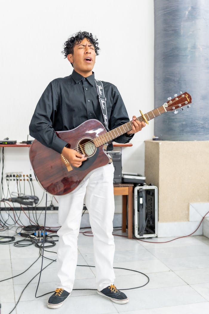 The Art of Drawing Readers In: Your attractive post title goes here A young male musician passionately plays acoustic guitar indoors in Mexico City.