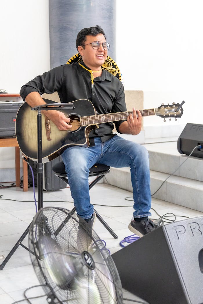 Man playing guitar and singing in a worship setting, Ciudad de México.